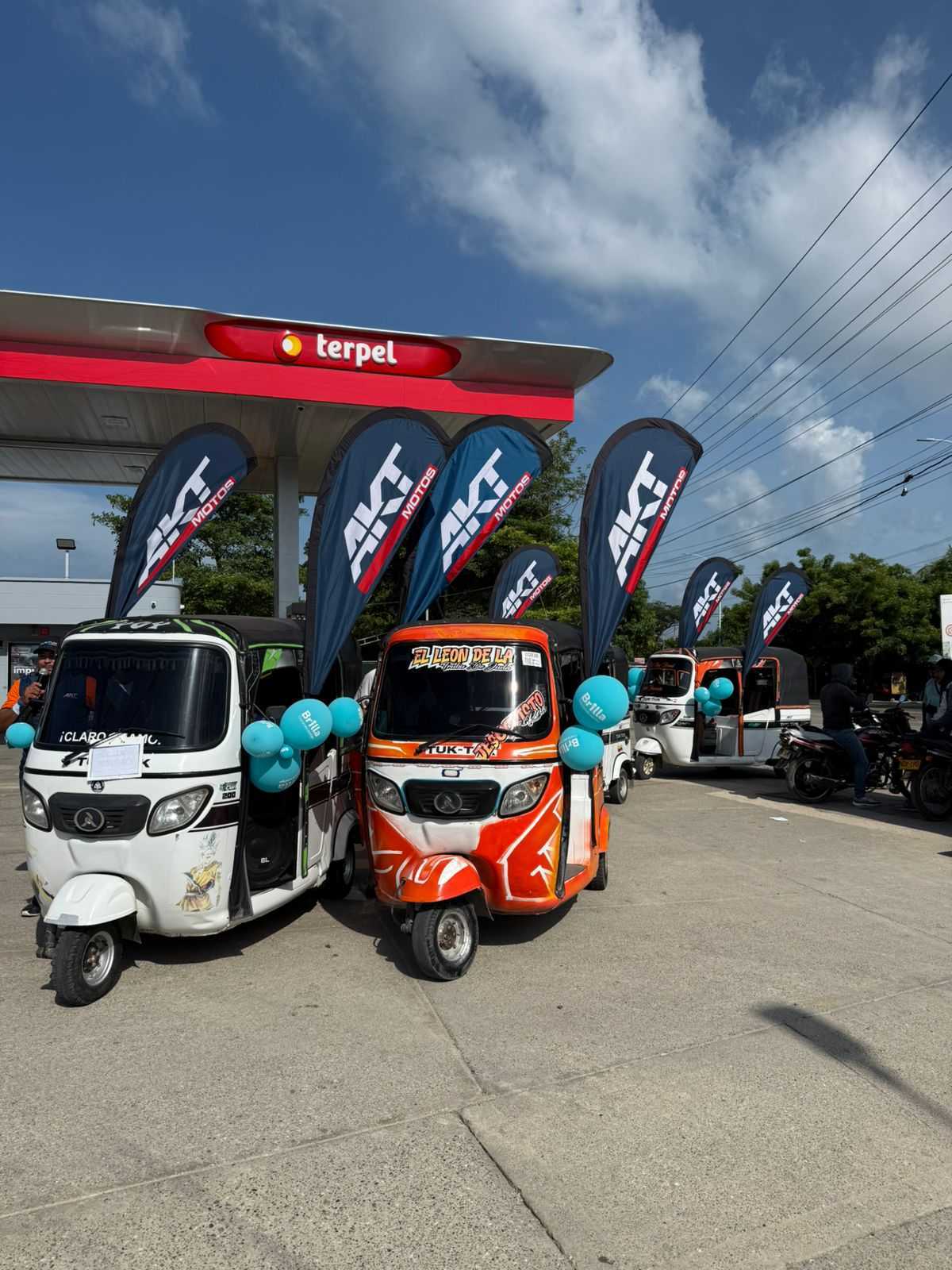AKT Motos fleet of Atul three-wheelers decorated for a Colombia sales promotion event