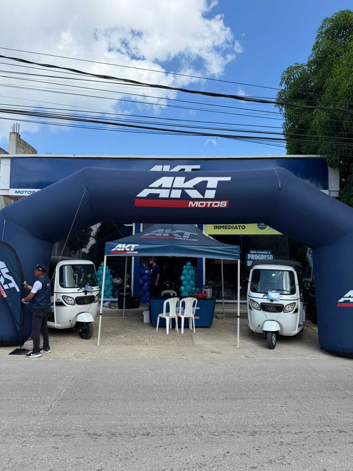 AKT Motos and Atul Auto sales promotion setup showcasing three-wheelers in Colombia